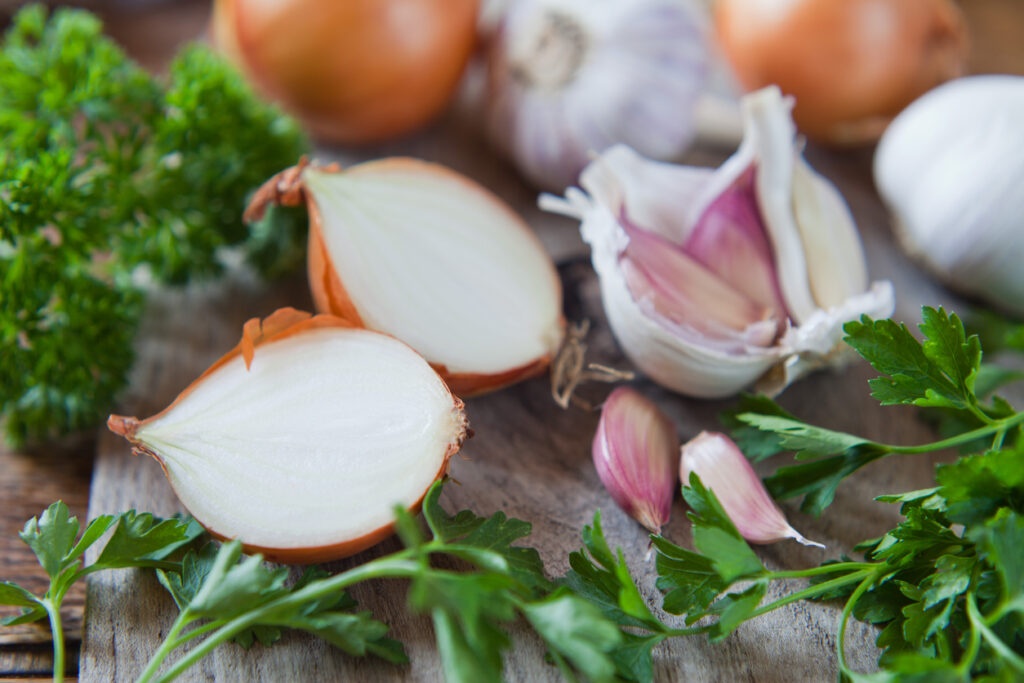 Garlic, onion and shallots on wooden board.